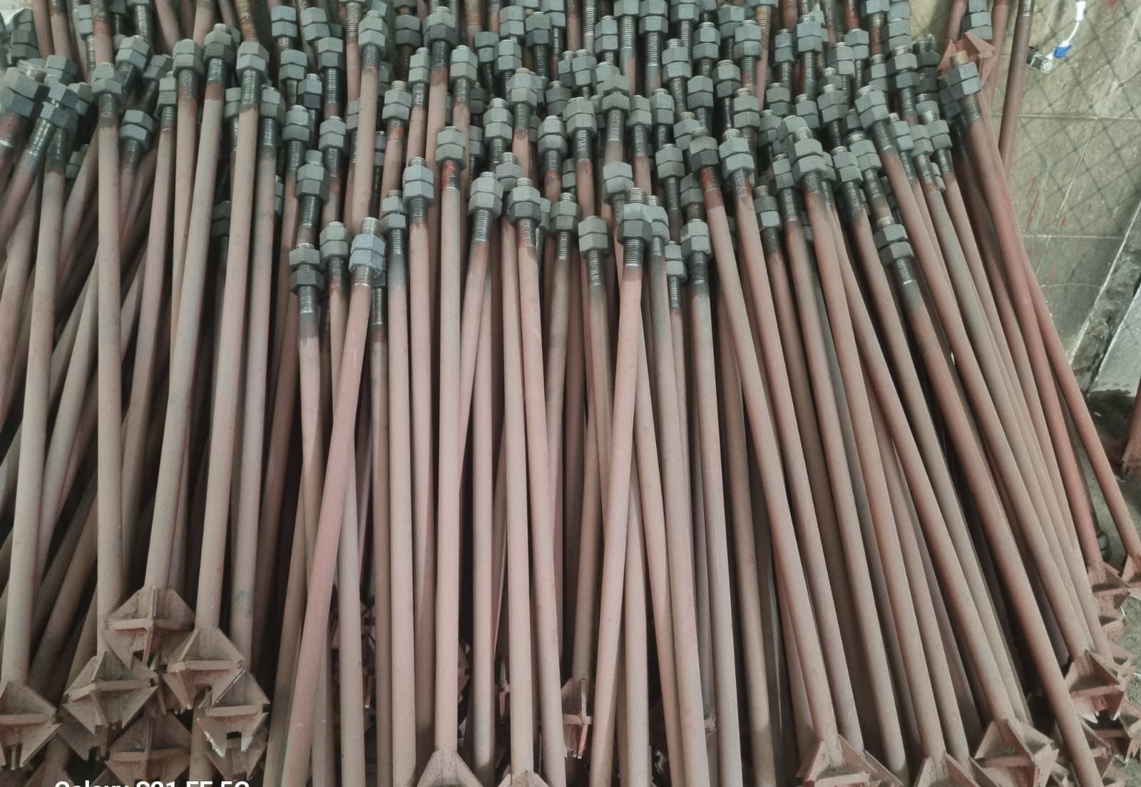 Close view of triangular stiffener gussets welded between rod and base plate on foundation bolt assemblies