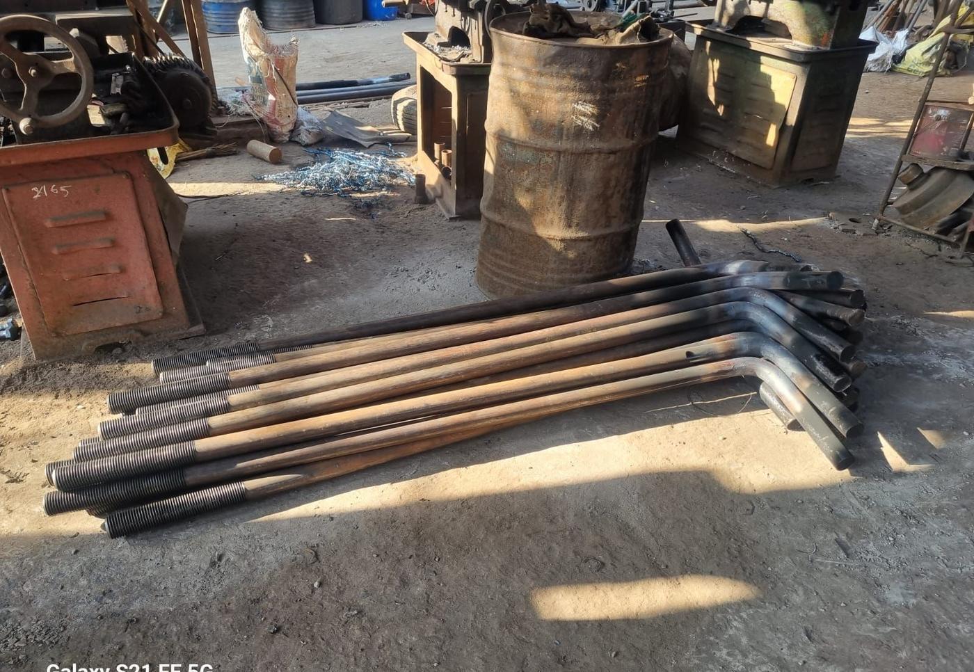 L type foundation bolts with 90 degree bend and rolled thread laid out on the shop floor